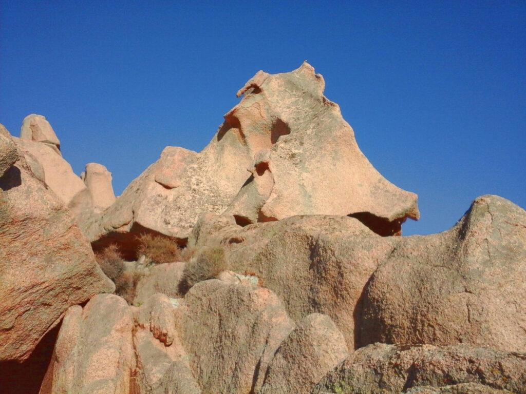Geformte Granitfelsen unter tiefblauem Himmel auf Sardinien.