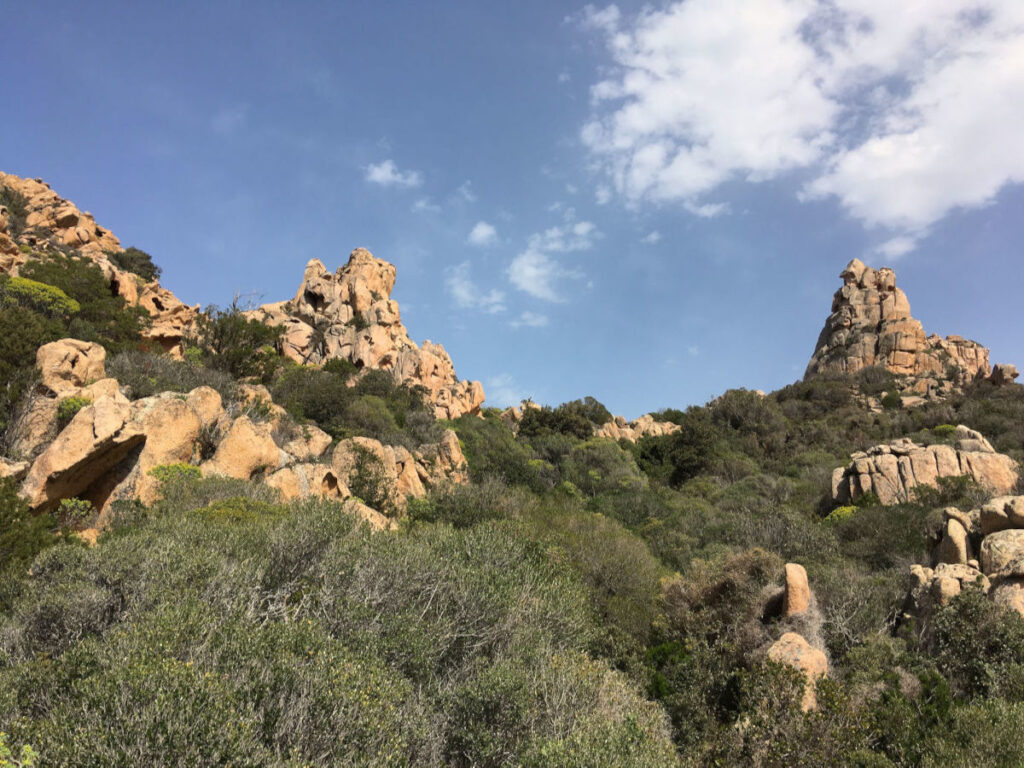 Weite Felsenlandschaft auf Sardinien mit mediterraner Vegetation und klarem Himmel am Retreatplatz.